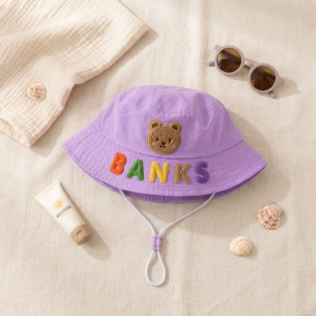 Personalized kids sun hat flat lay styled with summer baby accessories